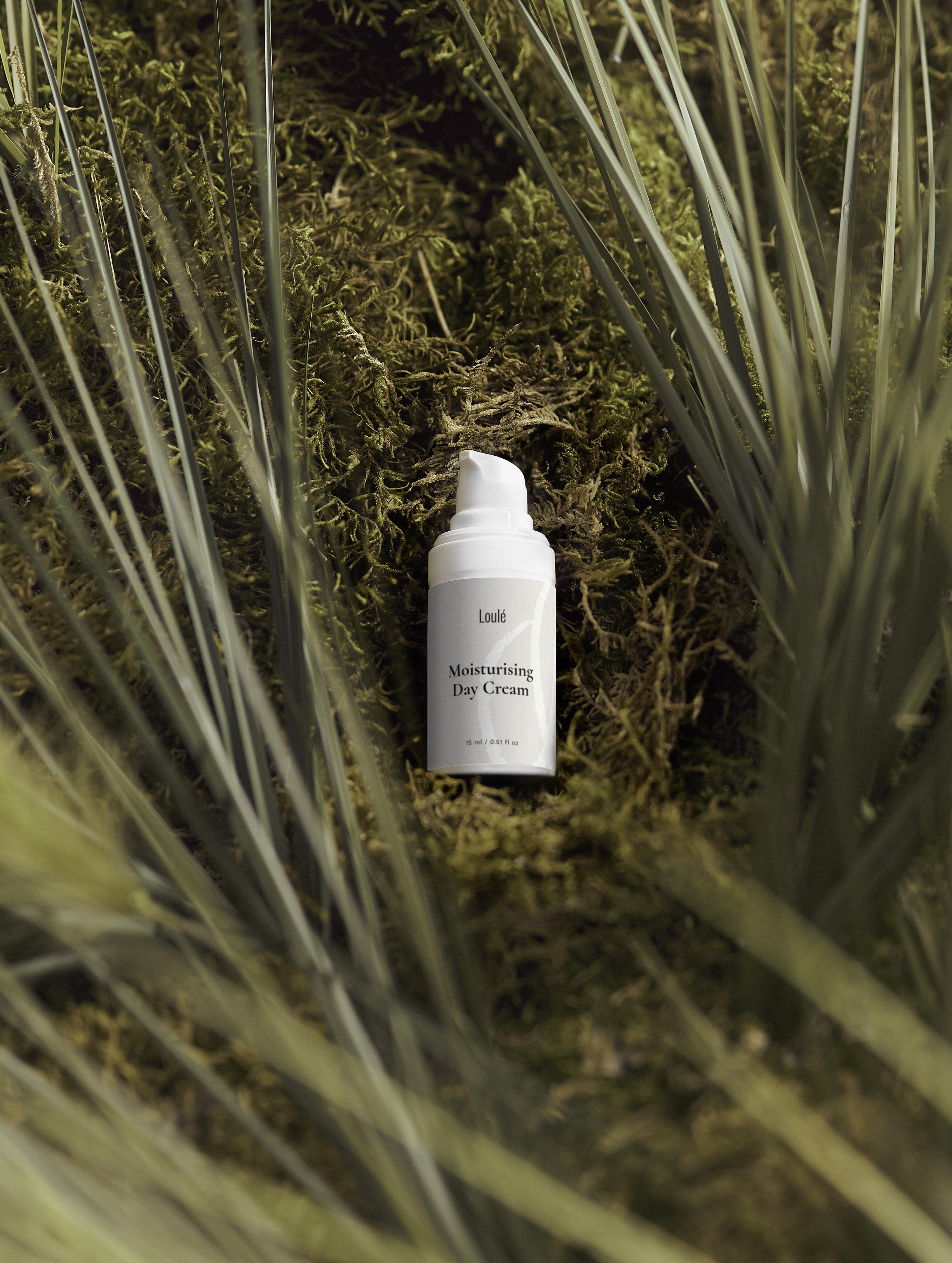Moisturising Day Cream with hyaluronic acid and aloe juice placed on lush green grass, ideal for dehydrated or normal skin types seeking a moisture boost.