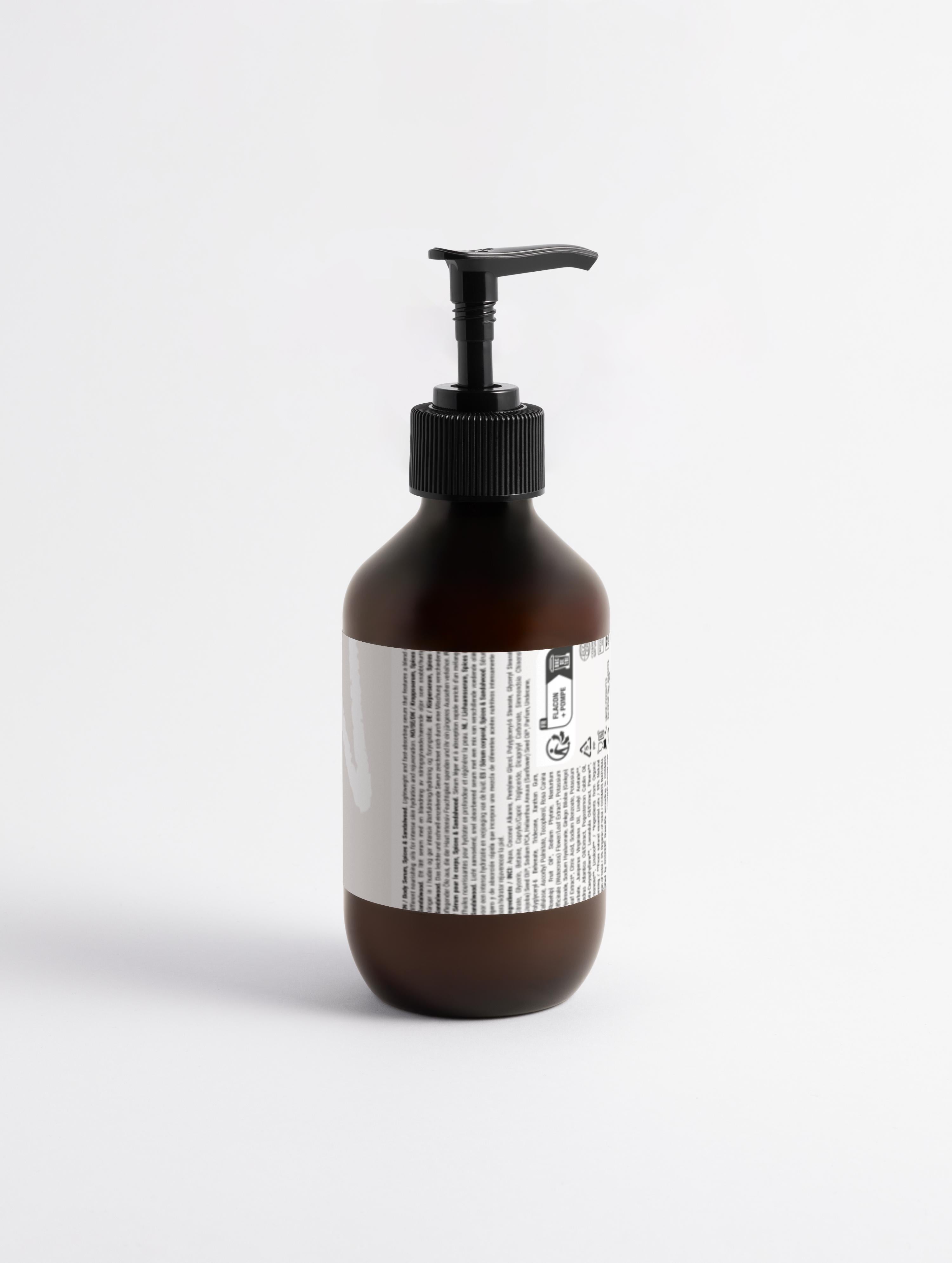 Silk Skin Body Serum, Spices & Sandalwood in amber pump bottle with ingredient label, ideal for deep hydration and soothing dry, dehydrated skin.