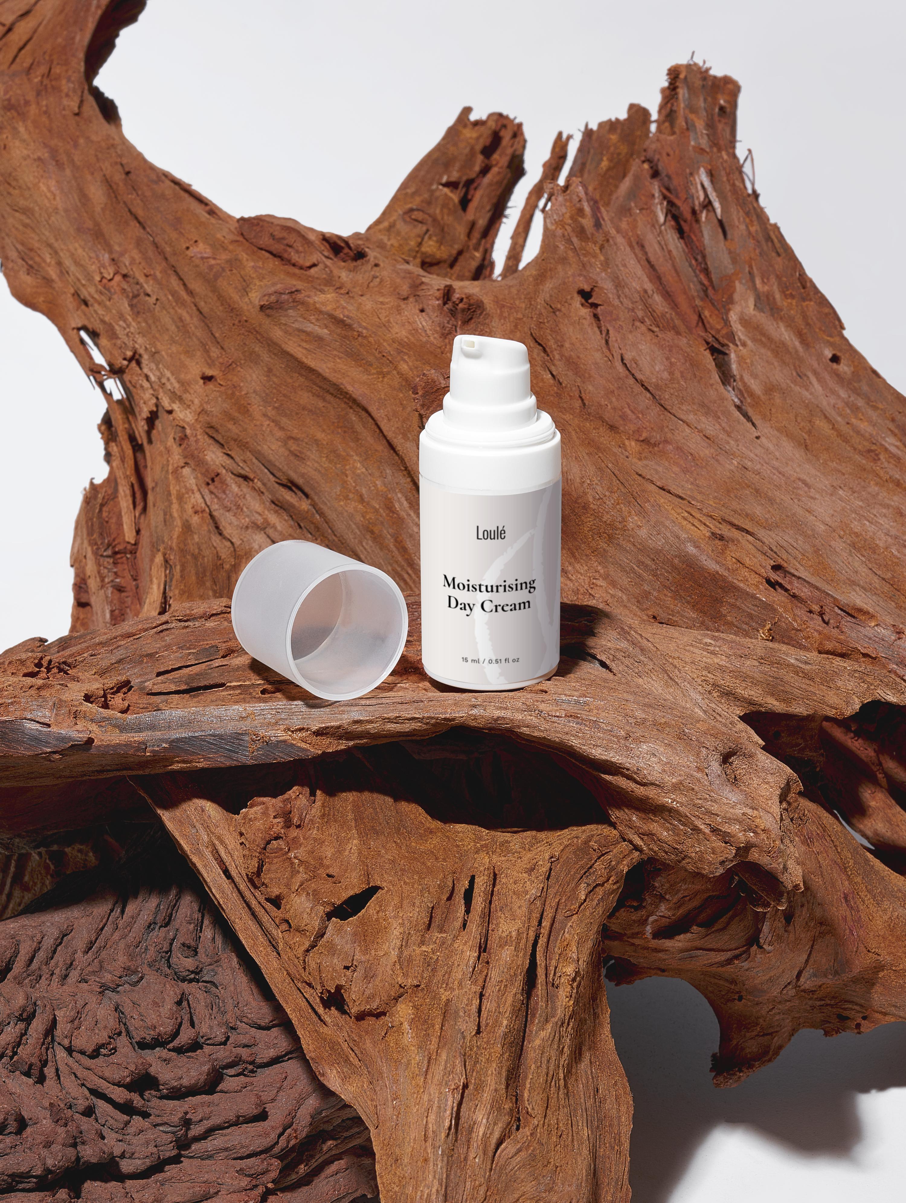 Moisturising Day Cream with hyaluronic acid and aloe juice in a sleek white bottle, placed on rustic wood for a natural skincare aesthetic.