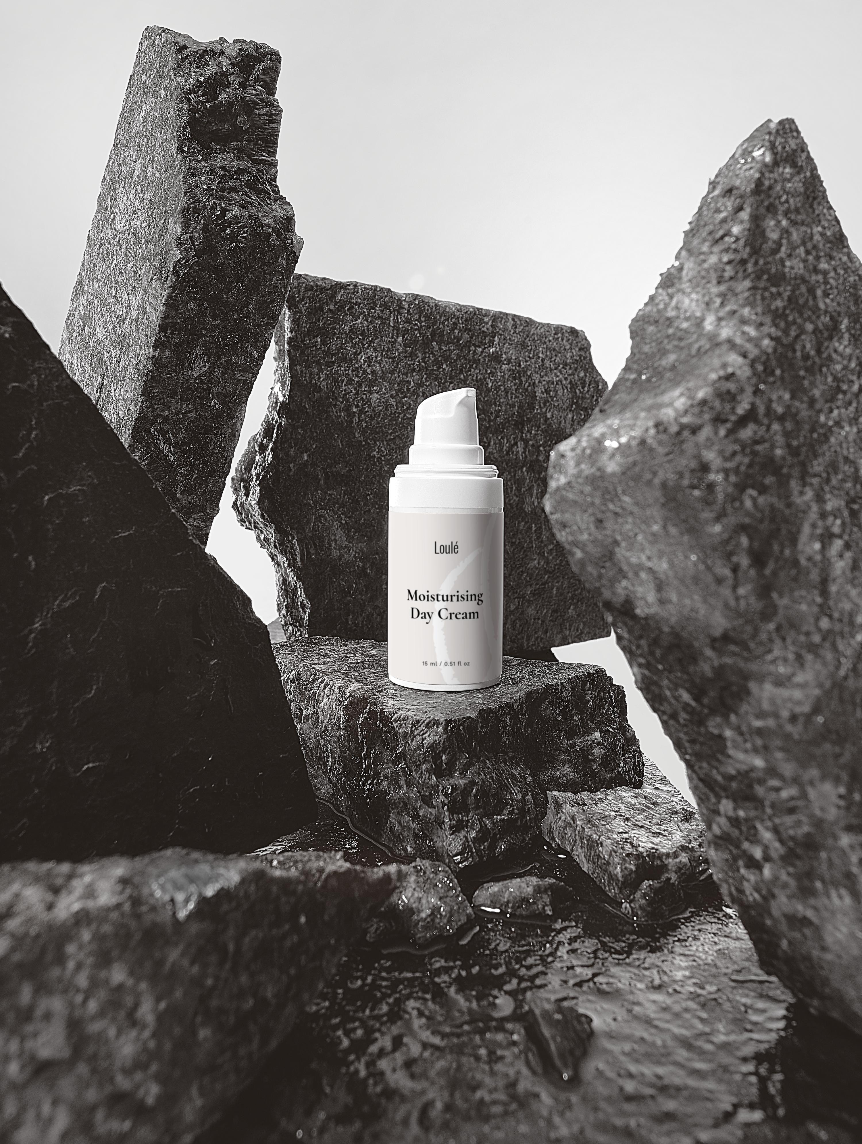 Moisturising Day Cream with hyaluronic acid and aloe juice for dehydrated skin, displayed among dark stone slabs for a luxurious skincare aesthetic.