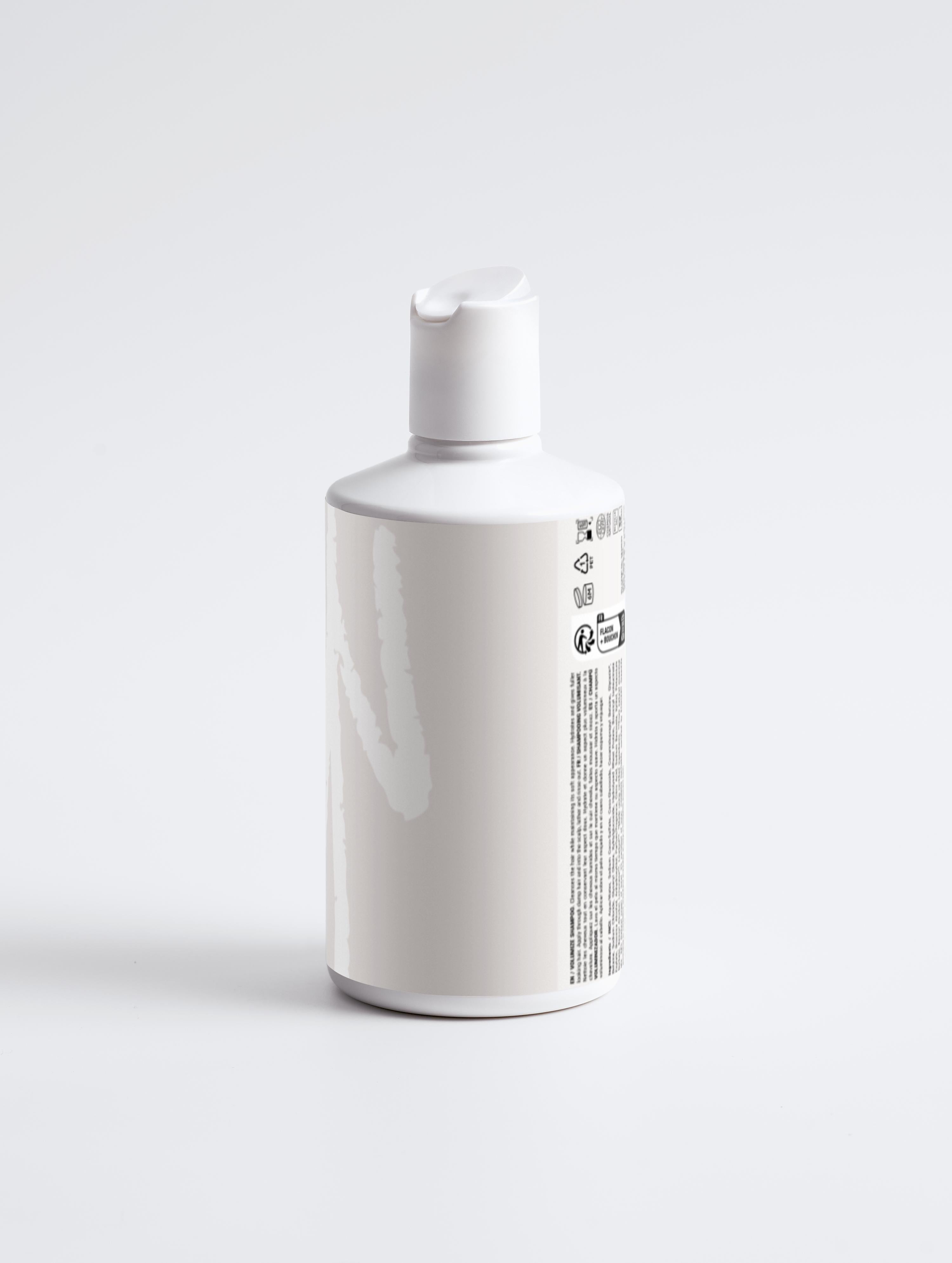 Nourish and Volumize Shampoo in sleek white bottle with pump cap, ideal for adding volume and strength to dry, flat hair using wheat protein and betaine.